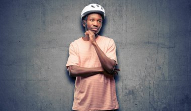 Siyah adam Bisiklet kask düşünme ve şüphe ve merak ifade arıyorum