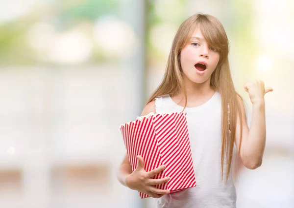 Junges Blondes Kleinkind Mit Popcornpackung Der Hand Und Erhobenem Finger — Stockfoto