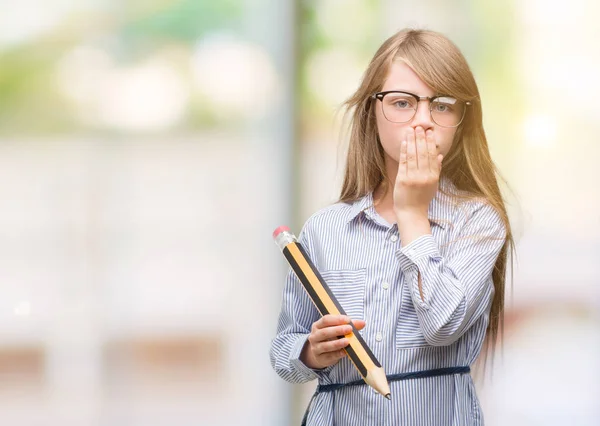 Młoda Blondynka Dziecko Trzymając Wielki Ołówek Pokrywa Usta Ręką Szoku — Zdjęcie stockowe