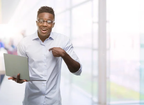自分自身に驚き顔ポインティング指でラップトップ コンピューターを使用して若いアフリカ系アメリカ人のビジネスマン — ストック写真