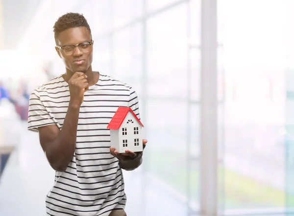 年轻的非洲裔美国男子举行的房子严肃的面孔思考问题 非常困惑的想法 — 图库照片