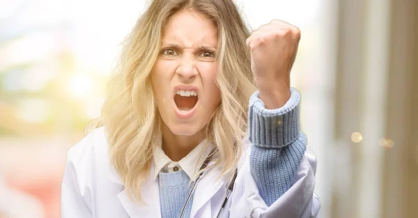 Young doctor woman, medical professional irritated and angry expressing negative emotion, annoyed with someone