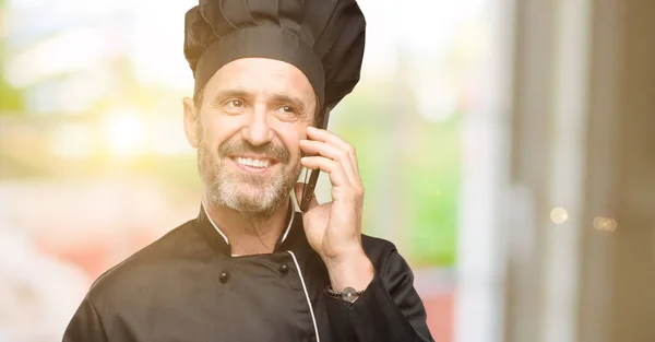 Cozinheiro Sênior Homem Vestindo Chapéu Chef Feliz Falando Usando Telefone — Fotografia de Stock