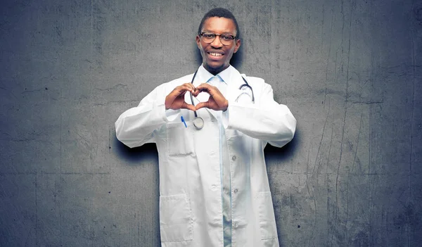 Young black doctor, medical professional happy showing love with hands in heart shape expressing healthy and marriage symbol