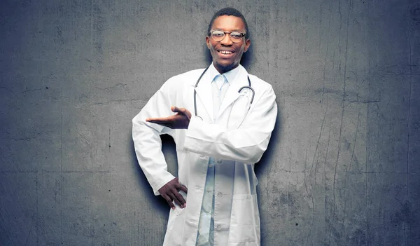 Young black doctor, medical professional holding something in empty hand