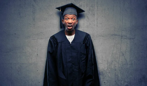Young african graduate student black man scared in shock, expressing panic and fear