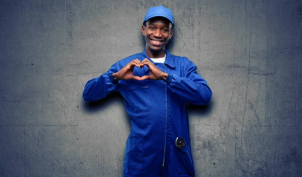 African black plumber man happy showing love with hands in heart shape expressing healthy and marriage symbol