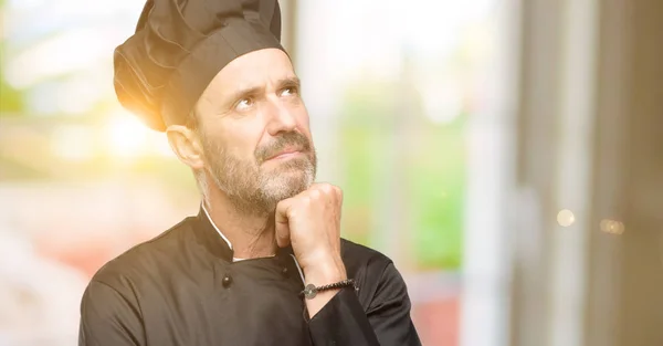 资深厨师人 穿着厨师帽思考和寻找表达怀疑和疑惑 — 图库照片