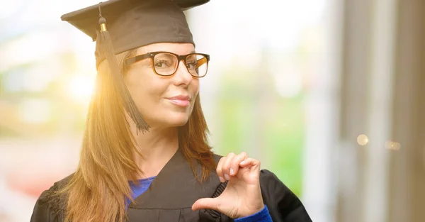 Senior graduate student woman proud, excited and arrogant, pointing with victory face