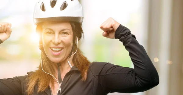 中年骑自行车的妇女使用耳机高兴和兴奋庆祝胜利表达了巨大的成功 能量和积极的情绪 庆祝新工作快乐 — 图库照片