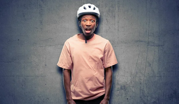 バイクのヘルメットを身に着けている黒人男性を怖がってショック パニックと恐怖を表現します — ストック写真
