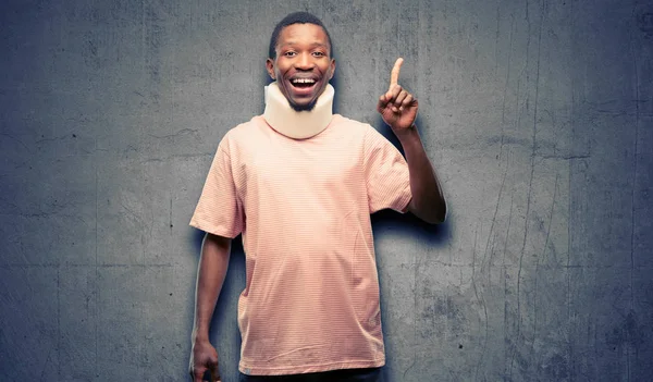 Injured african black man wearing neck brace pointing away side with finger