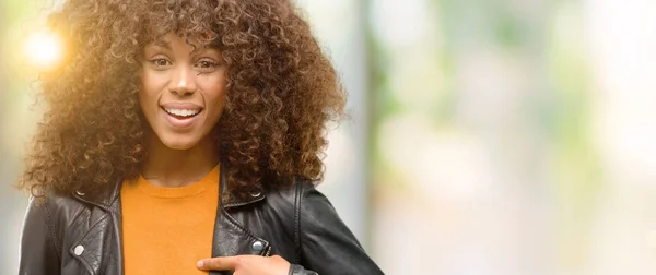 Afrikanische Amerikanerin Trägt Lederjacke Mit Überraschungsgesicht Und Zeigt Mit Dem — Stockfoto