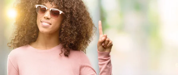 Afroamerikanska Kvinnan Bär Rosa Solglasögon Visar Och Pekar Uppåt Med — Stockfoto