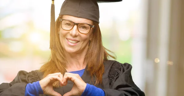 Senior graduate student woman happy showing love with hands in heart shape expressing healthy and marriage symbol