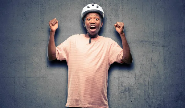 身穿自行车头盔的黑人男子高兴和兴奋庆祝胜利表达了巨大的成功 能量和积极的情绪 庆祝新工作快乐 — 图库照片