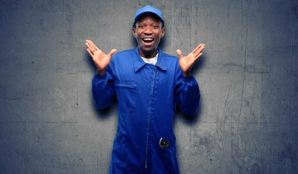 African black plumber man happy and surprised cheering expressing wow gesture