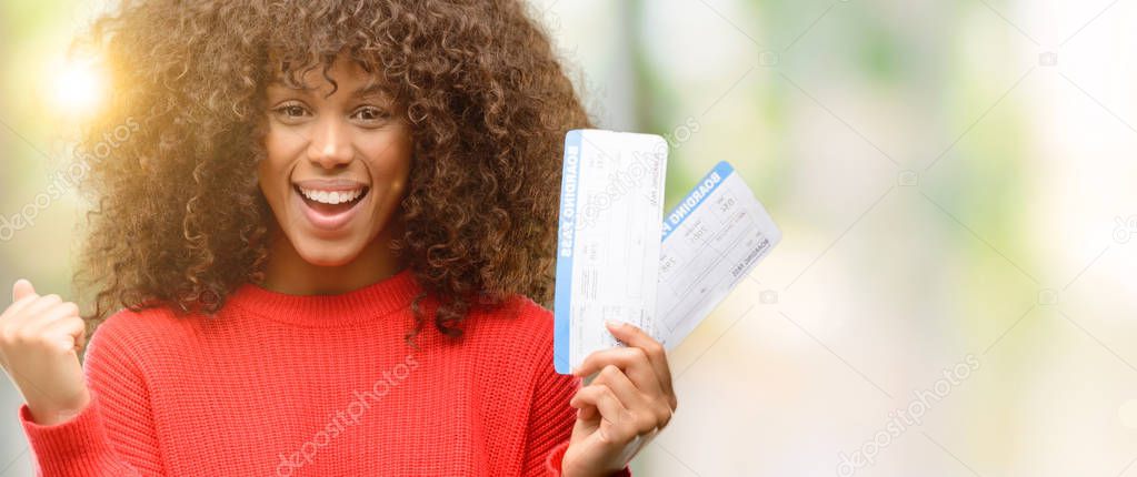 African american woman holding airline boarding pass tickets screaming proud and celebrating victory and success very excited, cheering emotion