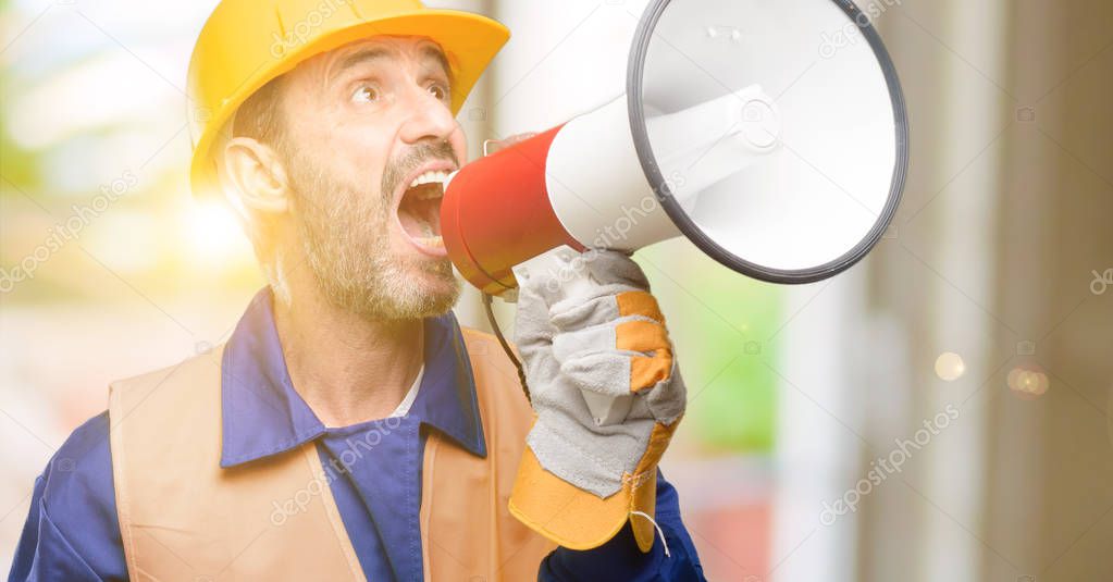Senior engineer man, construction worker communicates shouting loud holding a megaphone, expressing success and positive concept, idea for marketing or sales