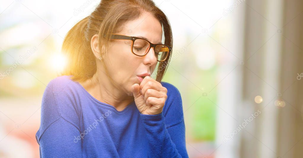 Middle age woman wearing wool sweater and glasses sick and coughing, suffering asthma or bronchitis, medicine concept