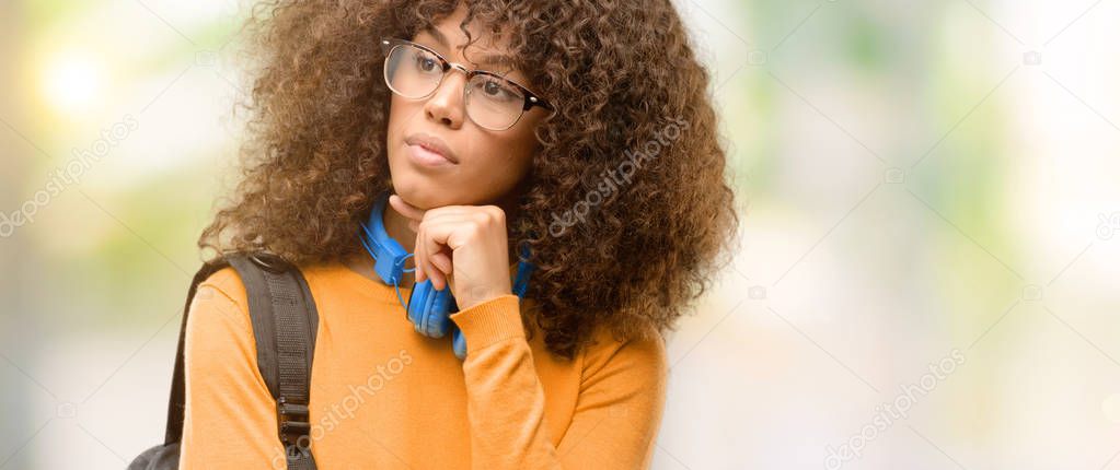 African american student woman thinking and looking up expressing doubt and wonder