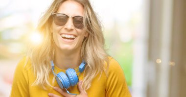 Kendinden emin ve mutlu bir büyük doğal gülümseme gülmek ile kulaklık ile genç güzel kadın