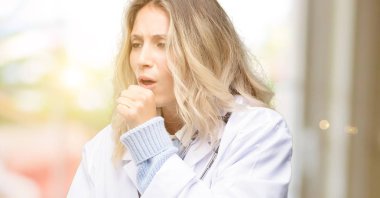 Young doctor woman, medical professional sick and coughing, suffering asthma or bronchitis, medicine concept clipart