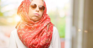 Uykulu ifade, çok çalıştırılıyordu ve yorgun ile hijab giyen orta yaş Müslüman Arap kadın