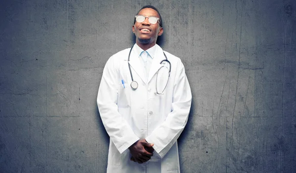 Young black doctor, medical professional thinking and looking up expressing doubt and wonder