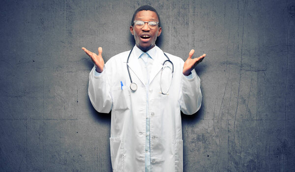 Young black doctor, medical professional happy and surprised cheering expressing wow gesture