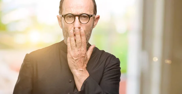 Priest religion man covers mouth in shock, looks shy, expressing silence and mistake concepts, scared