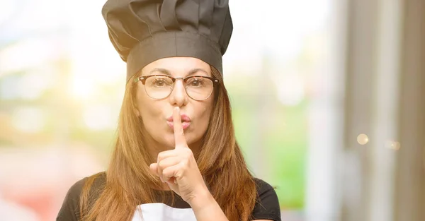 中年厨师长用食指在嘴唇上戴着主厨围裙 要求安静 沉默和秘密概念 — 图库照片