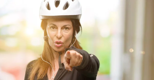 Middle Age Cyclist Woman Using Earphones Pointing Front Finger — Stock Photo, Image