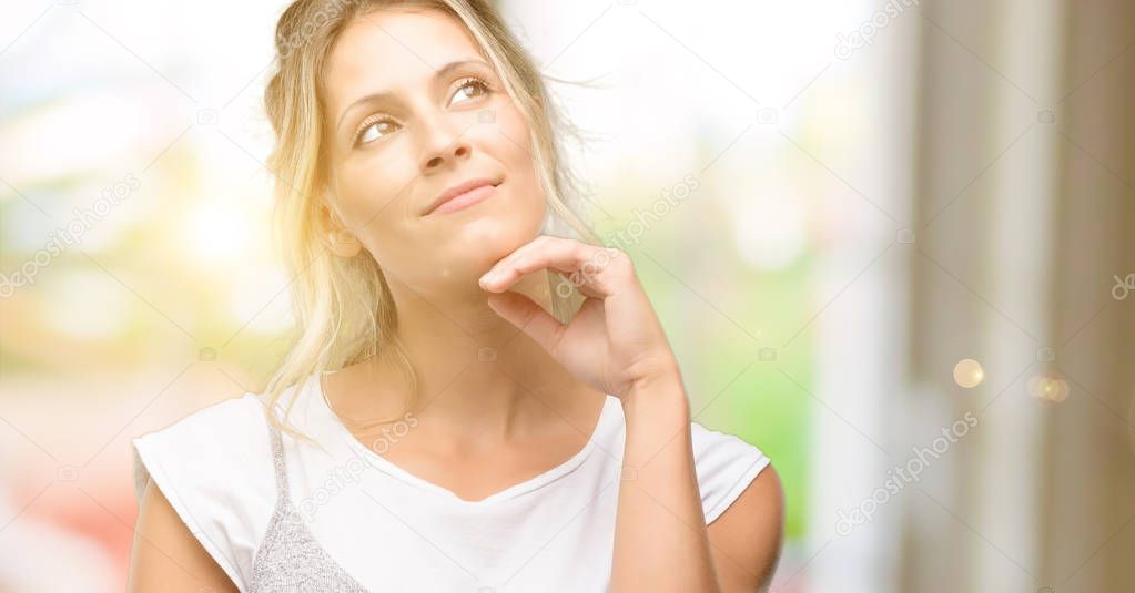 Young beautiful woman thinking and looking up expressing doubt and wonder