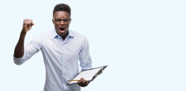 Afrikalı Amerikalı genç adam bir clipboarad rahatsız tutarak ve boşa çıkarmak ile öfke, çılgın ve yükseltilmiş eliyle diye bağıran öfke kavramı bağırarak.