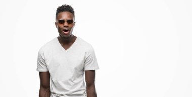 Afro-Amerikan delikanlı bir sürpriz yüz, korkuyor ve heyecanlı korku ifadesi ile şok korkmuş güneş gözlüğü takıyor