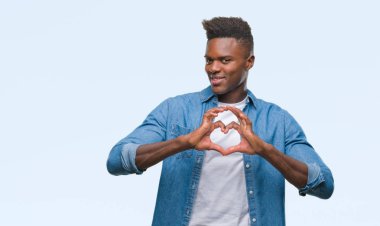 Afrikalı-Amerikalı genç aşık kalp simgesi ve elleriyle şekil gösteren gülümseyen izole arka plan üzerinde. Romantik kavramı.