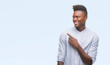 Genç Afro-Amerikan adam izole arka neşeli bir gülümseme ile el ve parmak kadar kameraya bakarak yüzündeki mutlu ve doğal ifade ile yan ile işaret yüz üzerinden.