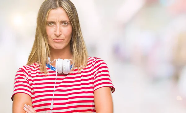 Junge Schöne Frau Mit Kopfhörer Über Isoliertem Hintergrund Skeptisch Und — Stockfoto