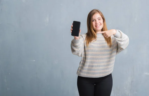 Mujer Adulta Joven Sobre Pared Grunge Gris Que Muestra Pantalla —  Fotos de Stock