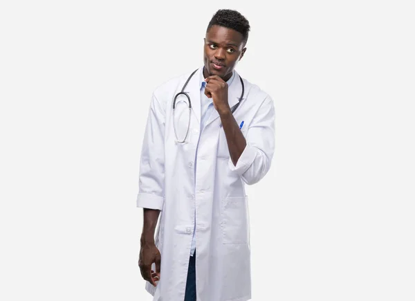Joven Afroamericano Hombre Usando Médico Abrigo Serio Cara Pensando Pregunta — Foto de Stock