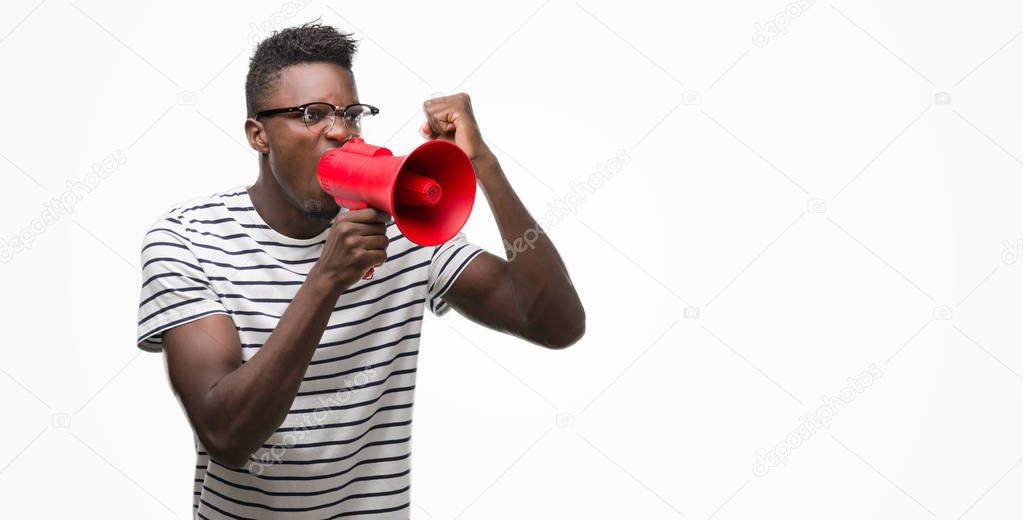 Young african american man holding megaphone annoyed and frustrated shouting with anger, crazy and yelling with raised hand, anger concept