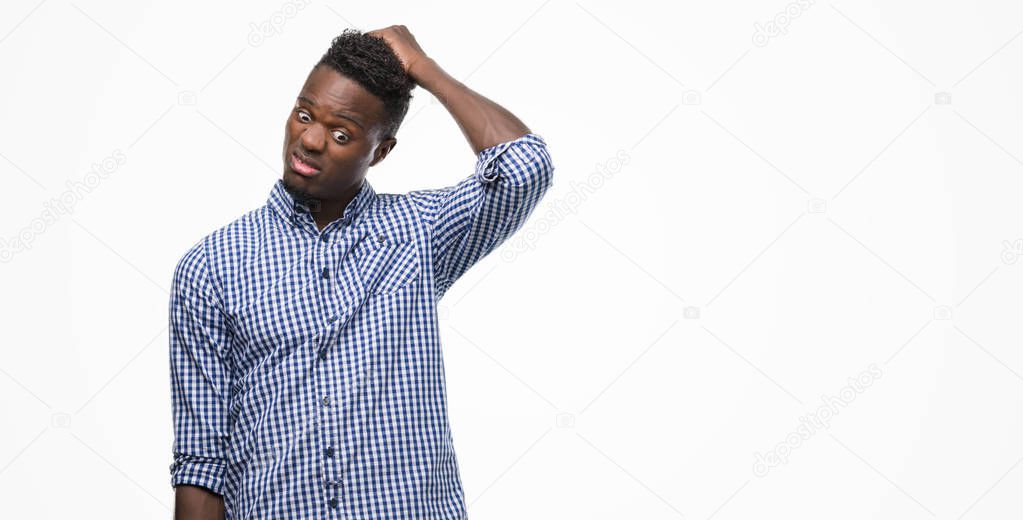 Young african american man wearing blue shirt confuse and wonder about question. Uncertain with doubt, thinking with hand on head. Pensive concept.