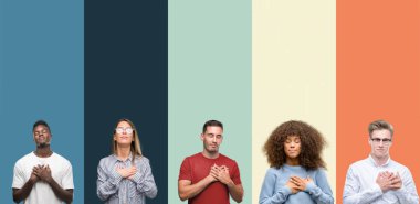 Group of people over vintage colors background smiling with hands on chest with closed eyes and grateful gesture on face. Health concept. clipart