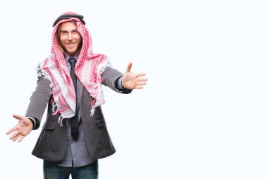 Genç yakışıklı Arap adam uzun saçlı sarılmak için kollarını açarak gülümseyerek kameraya bakarak izole arka plan üzerinde keffiyeh giyiyor. Neşeli ifade kucaklayan mutluluk.