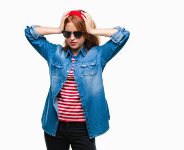 Genç güzel kadın giyiyor güneş gözlüğü çünkü umutsuz ve stresli baş ağrısı acı acı izole arka plan ve migren yüzünden. Ellerini kafasına.