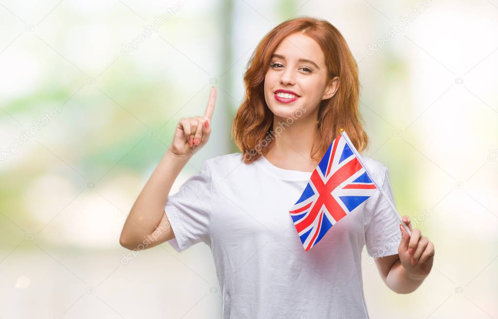 Young beautiful woman holding flag of united kingdom over isolated background surprised with an idea or question pointing finger with happy face, number one
