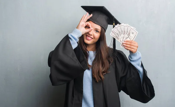 Joven Morena Sobre Pared Gris Grunge Usando Uniforme Graduado Sosteniendo —  Fotos de Stock