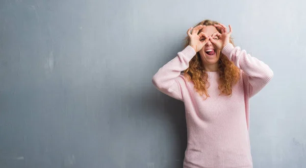 Unga Rödhårig Kvinna Över Grå Grunge Vägg Bär Rosa Tröja — Stockfoto