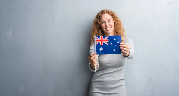 Joven Pelirroja Sobre Pared Grunge Gris Sosteniendo Bandera Australia Con —  Fotos de Stock